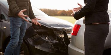 Kobieta i mężczyzna dyskutujący przy stłuczce aut