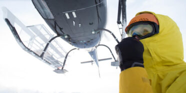 Helikopter i ratownik podczas akcji ratunkowej w górach zimą